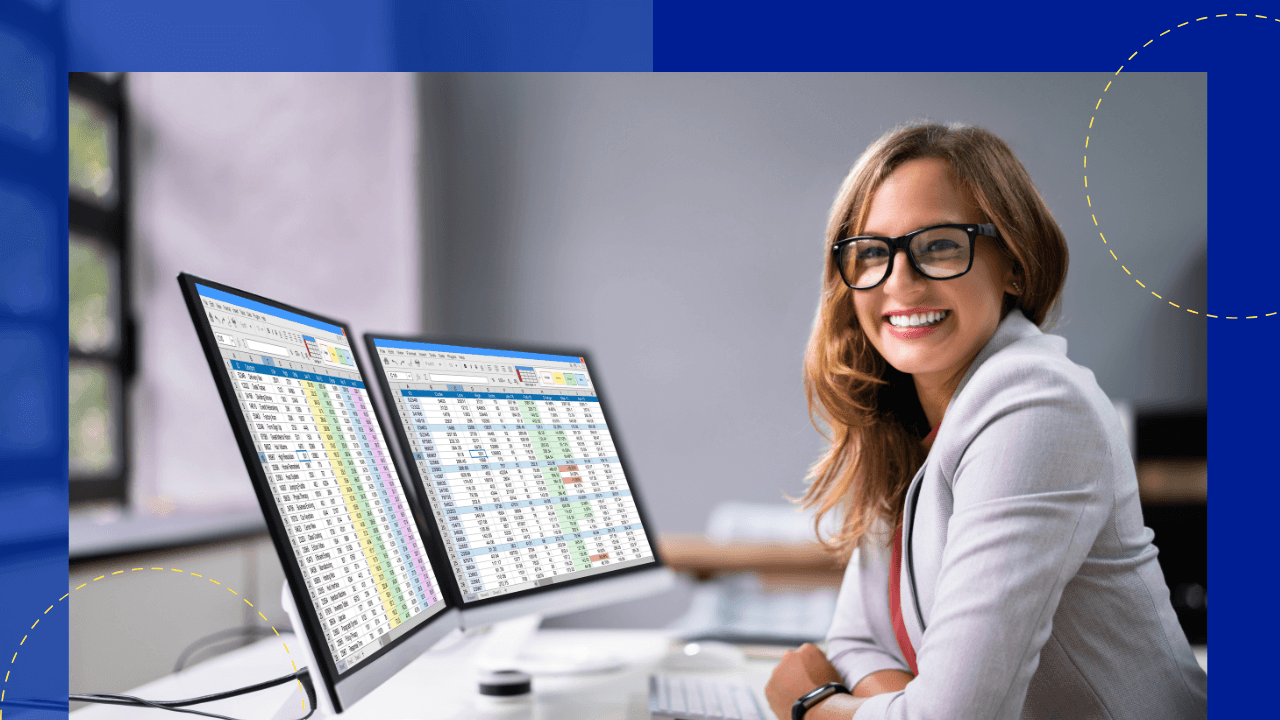 Smiling woman in glasses at dual monitors displaying a color-coded spreadsheet in a bright office, blue accent frame with dashed circles.