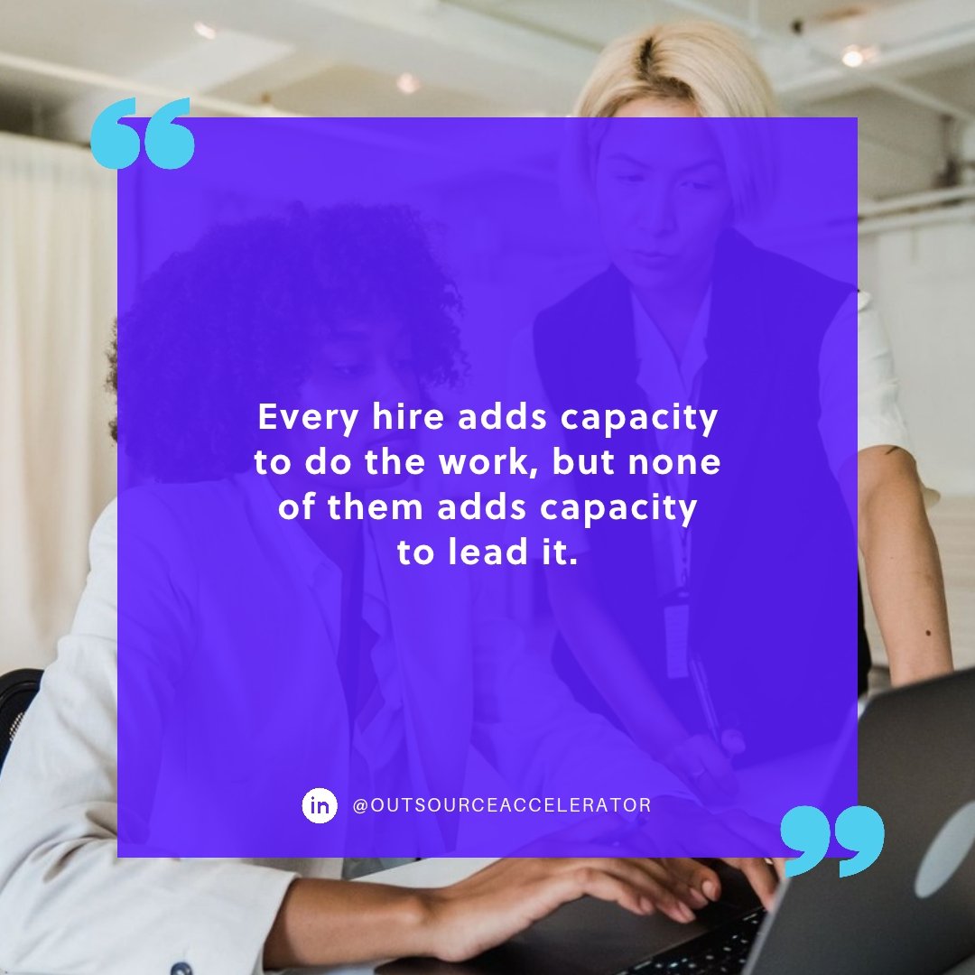 Team lead guiding a colleague working at a laptop